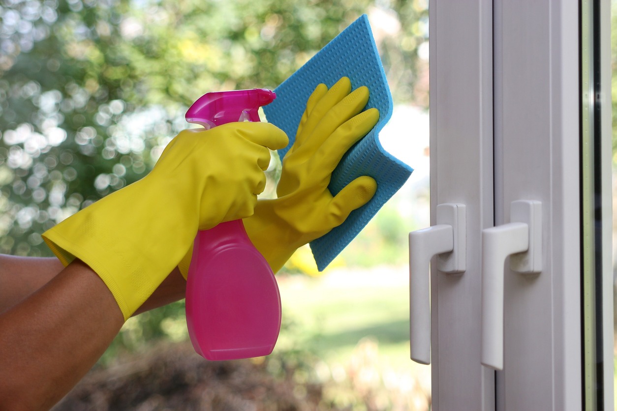 manos con guantes limpian cristales